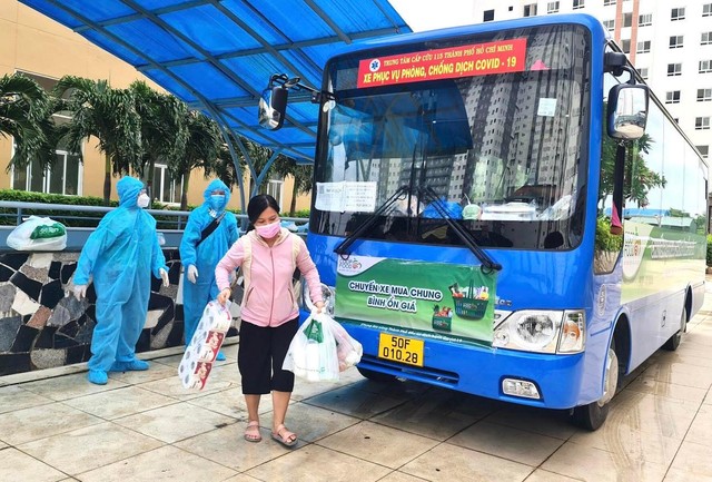 Người dân tại các chung cư lấy hàng hoá được vận chuyển bằng xe buýt "Chuyến xe mua chung - Bình ổn giá".