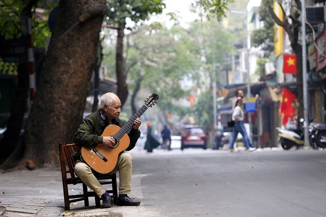 Ông Phạm Văn Phúc 85 tuổi ngẫu hứng với cây đàn ghi ta trên phố Hàng Vải.