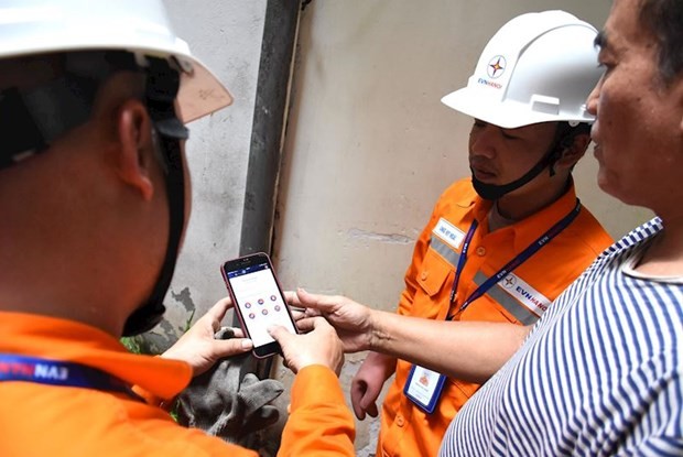 Nhân viên EVNHANOI hướng dẫn người dân ứng dụng công nghệ theo dõi việc sử dụng điện. (Ảnh: evnhanoi)