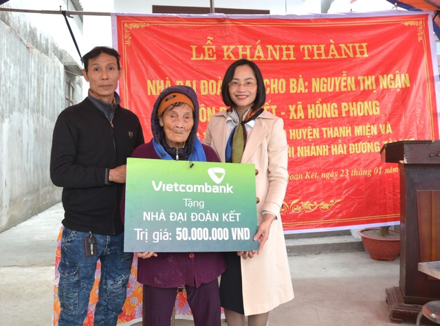 Bà Phạm Minh Đào - Phó Giám đốc Vietcombank Hải Dương (ngoài cùng bên phải) trao biển tặng nhà đại đoàn kết cho gia đình bà Nguyễn Thị Ngận, hộ nghèo thuộc huyện Thanh Miện, tỉnh Hải Dương Bà Phạm Minh Đào - Phó Giám đốc Vietcombank Hải Dương (ngoài cùng bên phải) trao biển tặng nhà đại đoàn kết cho gia đình bà Nguyễn Thị Ngận, hộ nghèo thuộc huyện Thanh Miện, tỉnh Hải Dương