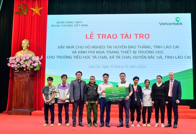 Ông Lê Hoàng Tùng - Phó Tổng Giám đốc Vietcombank (thứ 5 từ phải sang) cùng ông Đặng Việt Hùng - Giám đốc Vietcombank Lào Cai (ngoài cùng bên phải) trao biểu trưng hỗ trợ kinh phí xây dựng nhà cho 6 hộ gia đình khó khăn tại huyện Bảo Thắng, tỉnh Lào Cai Ông Lê Hoàng Tùng - Phó Tổng Giám đốc Vietcombank (thứ 5 từ phải sang) cùng ông Đặng Việt Hùng - Giám đốc Vietcombank Lào Cai (ngoài cùng bên phải) trao biểu trưng hỗ trợ kinh phí xây dựng nhà cho 6 hộ gia đình khó khăn tại huyện Bảo Thắng, tỉnh Lào Cai