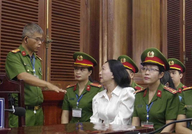 Bị cáo Lan trao đổi với cán bộ áp giải trước phiên tòa.