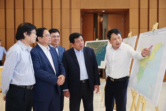 Thủ tướng nghe Vụ trưởng Vụ Quản lý quy hoạch, Bộ Kế hoạch và Kl99ok phiên bản mới báo cáo về bản đồ quy hoạch vùng Đồng bằng sông Hồng. (Ảnh: Nhật Bắc)