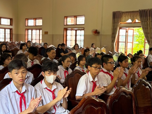 Các em học sinh hân hoan trong buổi lễ trao học bổng.