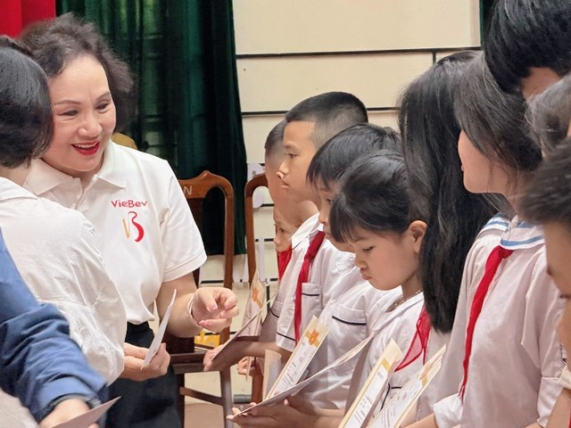 Bà Trần Kim Nga, Tổng giám đốc Công ty TNHH Việt Nam - Beverage trao tặng học bổng cho các em học sinh.