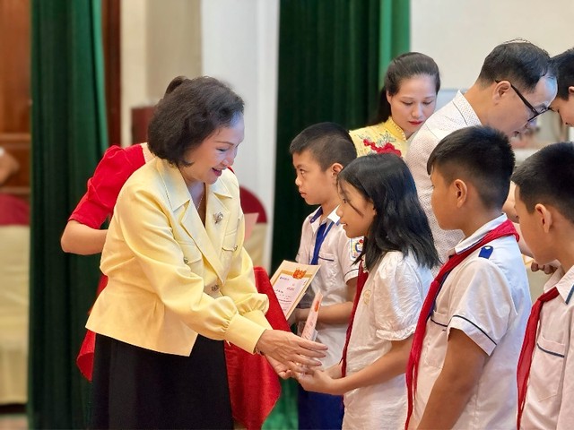 Bà Trần Kim Nga, Tổng giám đốc Công ty TNHH Việt Nam - Beverage trao giấy chứng nhận và học bổng cho các em học sinh.