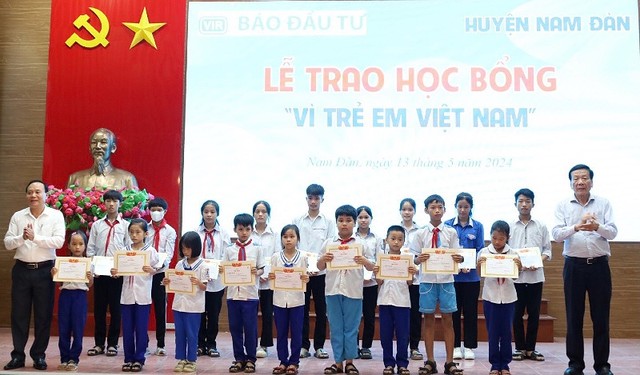 Ông Nguyễn Anh Tuấn, nguyên Tổng Biên tập Báo Kl99ok phiên bản mới; Nhà sáng lập Học bổng Vì trẻ em Việt Nam và ông Vương Hồng Thái, Uỷ viên Ban thường vụ Huyện uỷ trao học bổng và giấy chứng nhận cho các em học sinh.
