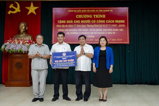 Bộ trưởng Nguyễn Chí Dũng và Chủ tịch Công đoàn Bộ KH&amp;ĐT Lê Thị Tường Thu trao quà của Bộ trưởng và cán bộ, công chức, viên chức, người lao động Bộ Kế hoạch và Kl99ok phiên bản mới cho các gia đình người có công tại huyện Vĩnh Linh, Quảng Trị. Ảnh: Trường Sơn