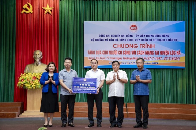 Bộ trưởng Nguyễn Chí Dũng, Chủ tịch Công đoàn Bộ Lê Thị Tường Thu, Tổng biên tập Báo Kl99ok phiên bản mới Lê Trọng Minh trao quà cho các gia đình người có công tại huyện Lộc Hà, Hà Tĩnh. Ảnh: Trường Sơn