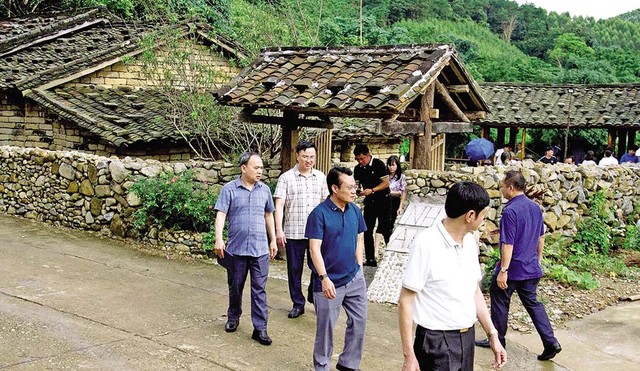 Khách du lịch tham quan nhà cổ của người Sán Chỉ ở xã Đại Dực. Ảnh: Xuân Thắng