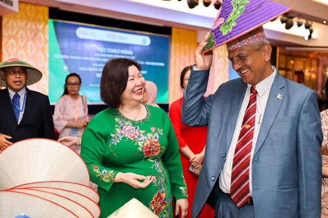Bà Cao Xuân Thu Vân, Chủ tịch Liên Minh Hợp tác xã Việt Nam giới thiệu nón lá Việt Nam đến bạn bè quốc tế.