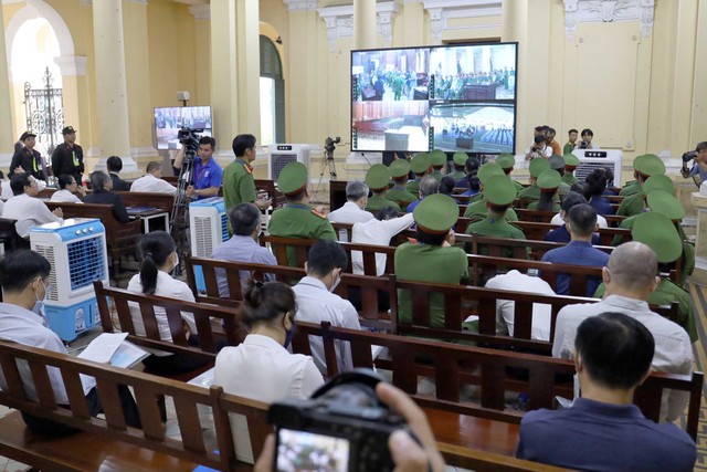 Các bị cáo theo dõi phiên toà thông qua màn hình bên ngoài phòng xét xử.