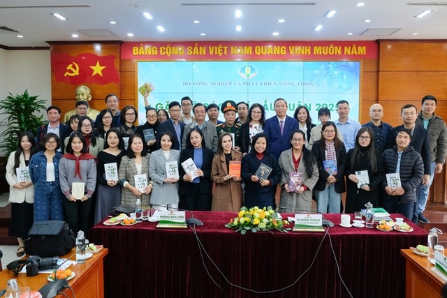 Bộ trưởng Lê Minh Hoan tặng sách và chụp hình lưu niệm với các phóng viên, nhà báo.