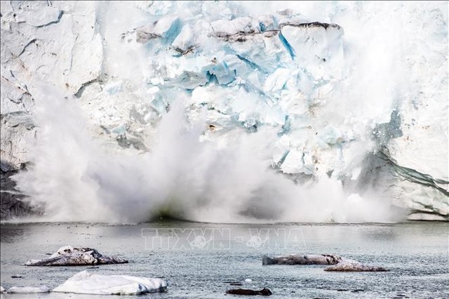 Băng tách ra từ một núi băng trên sông băng Apusiajik, gần Kulusuk, phía Đông Nam đảo Greenland. Ảnh: AFP/TTXVN