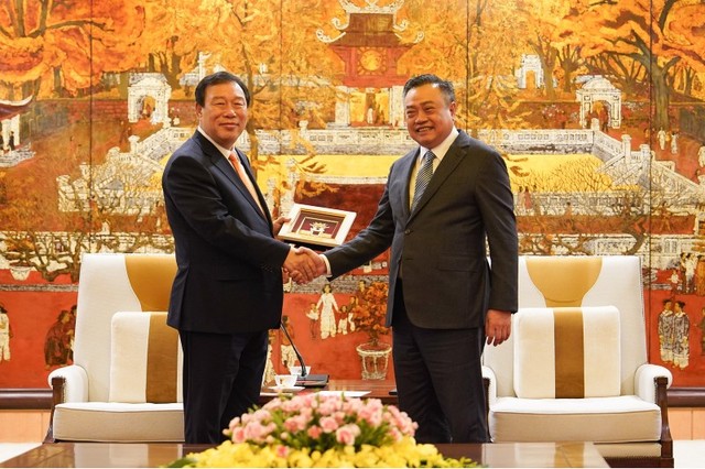 Chủ tịch UBND Thành phố Trần Sỹ Thanh trao quà lưu niệm của Hà Nội cho đoàn công tác thành phố Sejong. Ảnh: Hoàng Linh