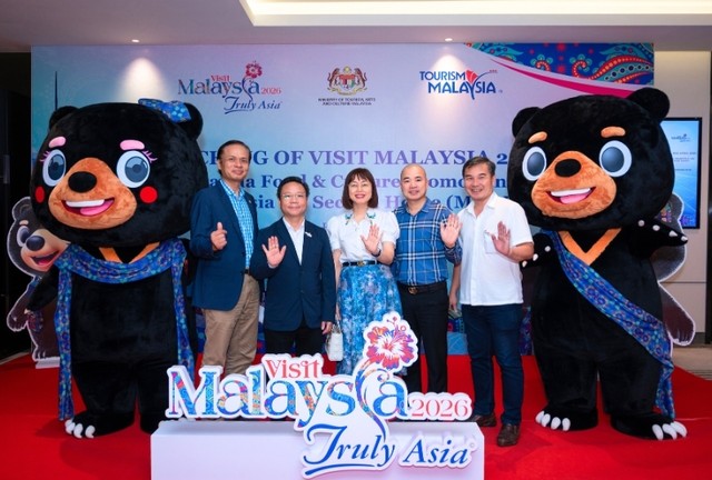 Các đại biểu chụp hình lưu niệm với logo và những chú gấu mặt trời Malaya - Wira &amp; Manja - linh vật của Visit Malaysia 2026.