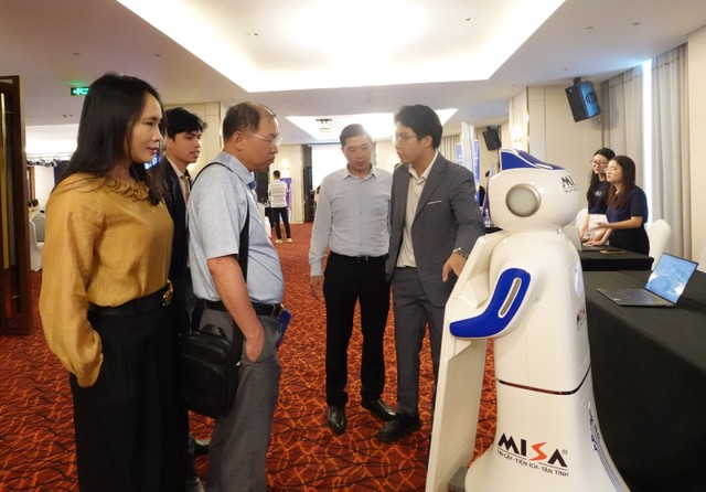 Các đại biểu tìm hiểu robot lễ tân Misa. Ảnh: Hồng Hạnh.