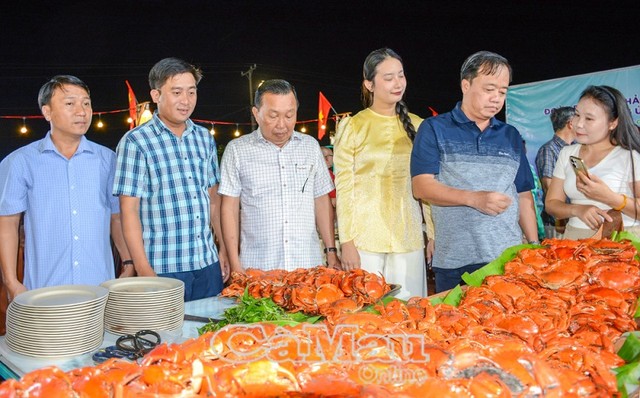 Lãnh đạo tỉnh Cà Mau và du khách trải nghiệm đặc sản cua Cà Mau. Ảnh: Baocamau online