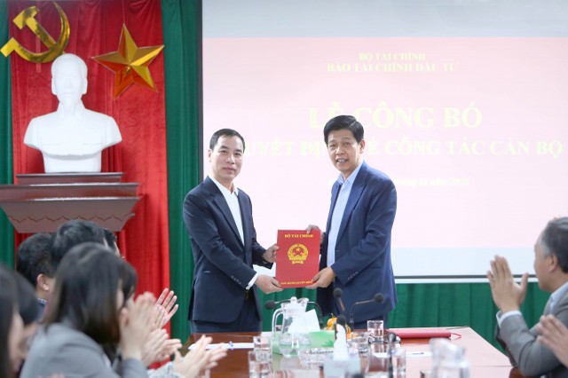 Thừa ủy quyền của Bộ trưởng Bộ Kl991.com nạp rút nhanh, Tổng Biên tập Báo Kl991.com nạp rút nhanh - Kl99ok phiên bản mới Đặng Khánh Thành (bên phải) trao quyết định điều động, bổ nhiệm Phó Tổng Biên tập Báo Kl991.com nạp rút nhanh - Kl99ok phiên bản mới cho ông Ngô Chí Tùng. Ảnh: Đức Minh