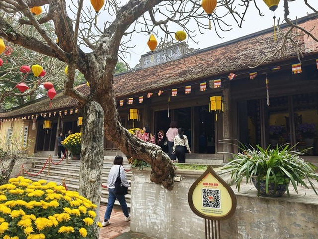 Du khách tham quan khu di sản văn hóa thế giới Côn Sơn - Kiếp Bạc có thể dùng điện thoại thông minh quét mã QR được đặt tại các điểm di tích tra cứu thông tin về lịch sử hình thành, kiến trúc, giá trị văn hóa của di sản cũng như các dịch vụ tiện ích liên quan. Ảnh: Thanh Sơn