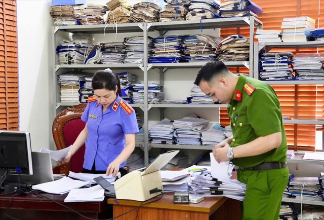 Lực lượng chức năng khám xét, thu giữ nhiều hồ sơ, chứng cứ liên quan tới vụ án.