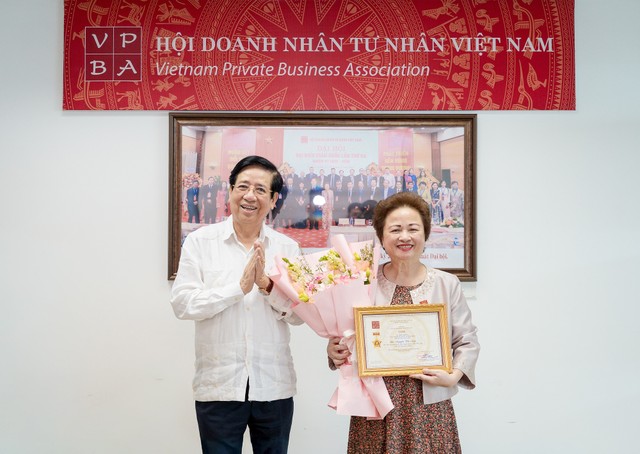 PGS.TS Nguyễn Trọng Điều, Chủ tịch Hội Doanh nhân Tư nhân Việt Nam, trao kỷ niệm chương cho bà Nguyễn Thị Nga