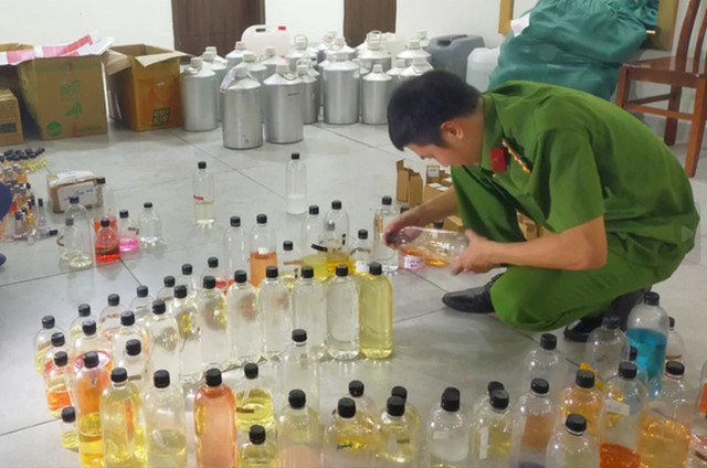 Cơ quan chức năng khám xét, thu giữ hàng nghìn chai nước hoa giả và nhiều tang vật. Ảnh: CA Thanh Hóa