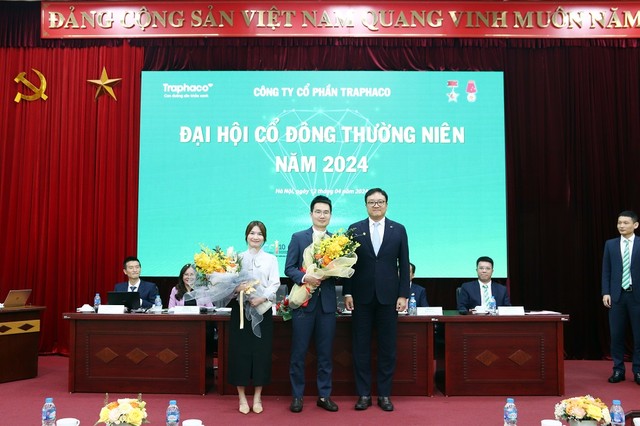 Ông Jun Woo Cha (đứng giữa), thành viên HĐQT mới của Traphaco nhận hoa chúc mừng từ Chủ tịch Chung Ji Kwang