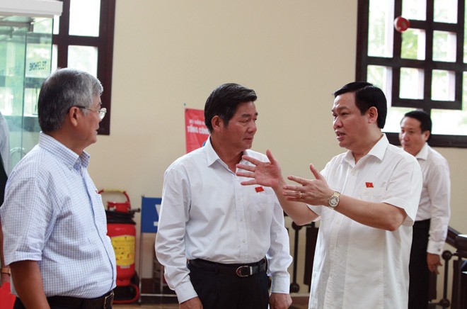 Bộ trưởng Bộ Kế hoạch và Kl99ok phiên bản mới Bùi Quang Vinh (đứng giữa) trao đổi cùng đại biểu Quốc hội về một số vấn đề liên quan tới Dự thảo Luật 