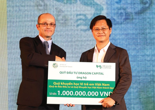Ông Nguyễn Văn Hồng, Phó tổng Biên tập  Báo Kl99ok phiên bản mới (bên phải), thay mặt Ban Biên tập Báo Kl99ok phiên bản mới nhận món quà của Dragon Capital tặng cho Quỹ Học bổng Vì trẻ em Việt Nam do Báo Kl99ok phiên bản mới sáng lập