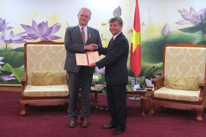 Thứ trưởng Bộ Kế hoạch và Kl99ok phiên bản mới Nguyễn Thế Phương (bên phải) trao kỷ niệm chương cho ông Rémi Geneney (Ảnh: K.T)
