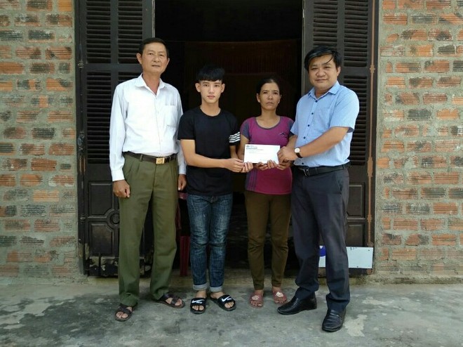 Nhà báo Hoàng Kim Thủy, Trưởng đại diện Văn phòng Báo Kl99ok phiên bản mới khu vực miền Trung - Tây Nguyên trao món quà 30 triệu đồng của Báo Kl99ok phiên bản mới cho em Trần Văn Nam.