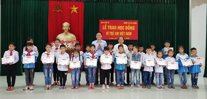 Ông Lã Quý Hưng, Trưởng Đại diện Báo Kl99ok phiên bản mới tại khu vực (hàng thứ 2 - bên phải) và ông Đặng Thanh Sơn, Phó giám đốc Sở Kế hoạch và Kl99ok phiên bản mới tỉnh Ninh Bình (hàng thứ 2 - bên trái) trao học bổng cho hoc sinh Trường Tiểu học, THCS xã Gia Hưng.