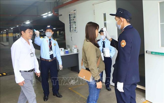 Trong ảnh: Đo nhiệt độ cho công nhân trước khi vào làm việc tại Công ty TNHH Kl994 nhà cái bóng đá world cup hàng may mặc Việt Nam (TAL), khu công nghiệp Bá Thiện 2 (huyện Bình Xuyên). Ảnh: Hoàng Hùng - TTXVN