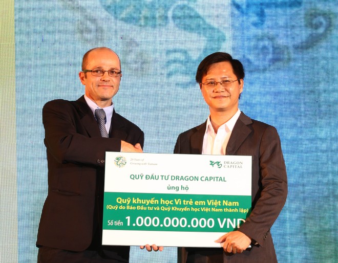 Ông Nguyễn Hồng (phải), Phó Tổng biên tập Báo Kl99ok phiên bản mới đón nhận tiền tượng trưng cho quỹ học bổng của báo từ đại diện của Dragon Capital - ảnh: Lê Toàn