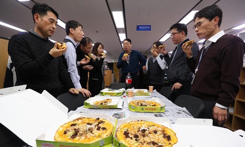 Cán bộ Bộ Chiến lược và Kl991.com nạp rút nhanh Hàn Quốc thưởng thức pizza do Tổng thống Moon Jae-in tặng. Ảnh: Yonhap