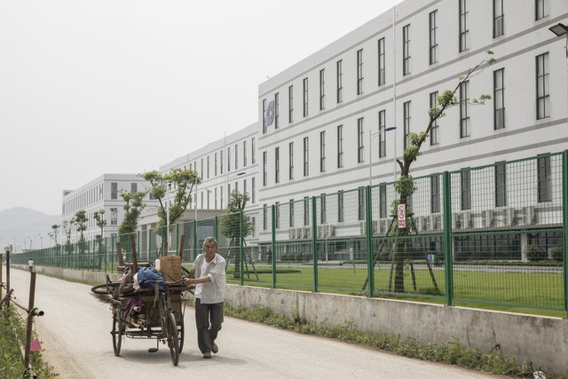 Một người đàn ông đang kéo một chiếc xe kéo phía trước nhà máy được điều hành bởi Kl994 game bài casino hấp dẫn Công nghệ Quang học Sunny. (Nguồn: Qilai Shen/Bloomberg).