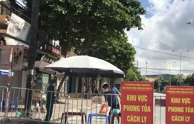 Người dân trong khu vực phong tỏa trên phố Ngô Quyền (Hải Dương) nhận thực phẩm tiếp tế tại hàng rào cách ly ngày 16/8. (Ảnh: Mạnh Minh/TTXVN)
.