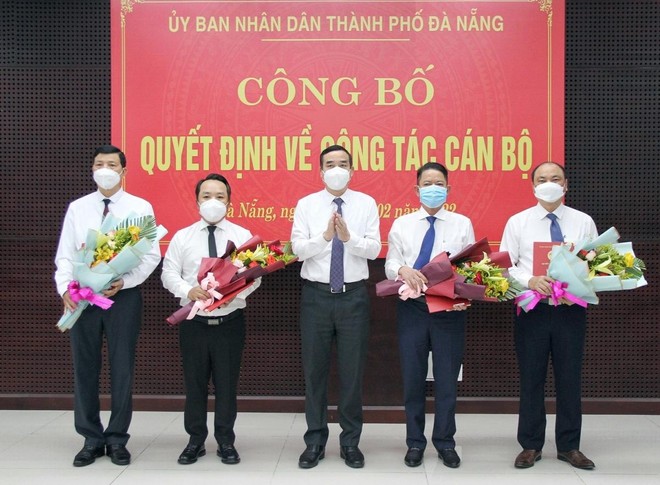 Ông Lê Trung Chinh (giữa), Chủ tịch UBND thành phố Đà Nẵng trao Quyết định và tặng hoa chúc mừng các cán bộ được điều động, bổ nhiệm vị trí công tác mới.