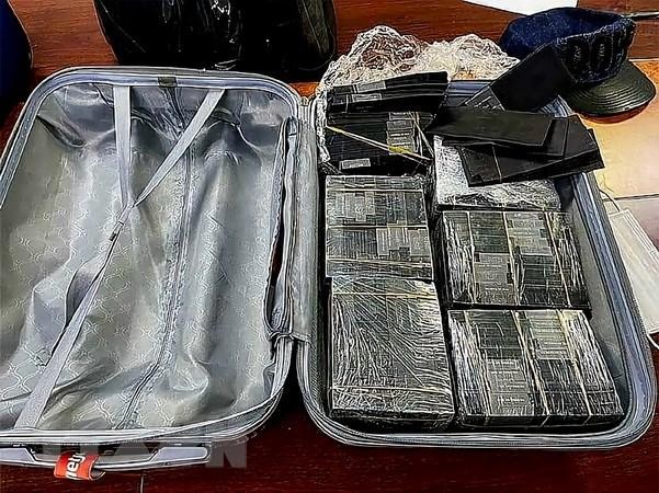 Cơ quan chức năng thu giữ số lượng lớn tiền mệnh giá 100 USD bị nhuộm đen bằng hóa chất. (Ảnh: TTXVN phát)
