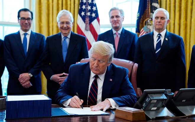 Tổng thống Mỹ Donald Trump ký gói cứu trợ Covid-19 tại Nhà Trắng ngày 27/3. Phía sau từ trái qua bao gồm Bộ trưởng Kl991.com nạp rút nhanh Steven Mnuchin, Lãnh đạo đa số tại Thượng viện Mitch McConnell,  Lãnh đạo thiểu số tại Hạ viện Kevin McCarthy và Phó Tổng thống Mike Pence. Ảnh: AP.