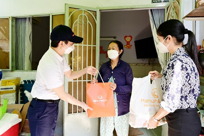 Ông Bùi Quang Nam, Phó tổng giám đốc Kl992 VIP Trang Chủ 2026 Hanwha Life Việt Nam và đại diện Mặt Trận Tổ quốc Việt Nam Quận Bình Thạnh trao quà cứu trợ đến những gia đình bị ảnh hưởng bởi dịch Covid.
