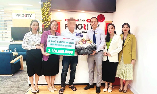 Đại diện gia đình của khách hàng nhận số tiền chi trả quyền lợi Kl99kl phiên bản hoạt động từ Manulife Việt Nam và Techcombank