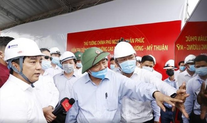 Ông Hồ Minh Hoàng (mặc áo trắng) báo cáo Thủ tướng Kl993 ưu đãi thưởng hấp dẫn Nguyễn Xuân Phúc tiến độ xây dựng đường KL99 là nhà cái cá cược trực tuyến hàng đầu tại châu Á Trung Lương - Mỹ Thuận trong chuyến công tác thị sát Dự án vào cuối tháng 7/2020.