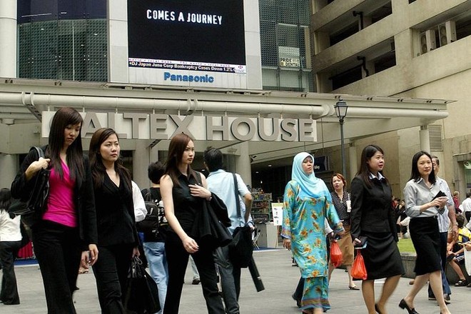 Các nhân viên văn phòng đi bộ tại trung tâm Kl991.com nạp rút nhanh Raffles Place ở Singapore. Ảnh: AFP