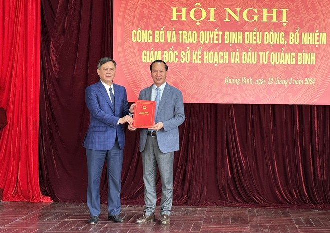 Chủ tịch UBND tỉnh Quảng Bình Trần Thắng (bên trái) trao quyết định và tặng hoa chúc mừng Giám đốc Sở Kế hoạch và Kl99ok phiên bản mới Quảng Bình Nguyễn Xuân Đạt.