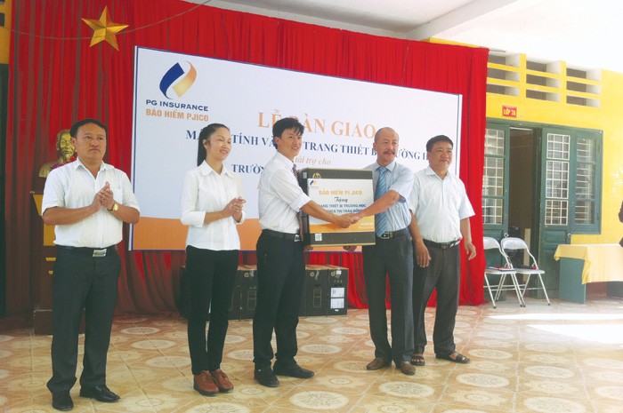 Ông Bùi Hoài Giang, Phó tổng giám đốc Tổng CTCP Kl99kl phiên bản hoạt động Petrolimex (PJICO) trao tặng tài trợ cho ông Nguyễn Trung Kiên, Hiệu trưởng Trường THCS Thị trấn Đồng Văn