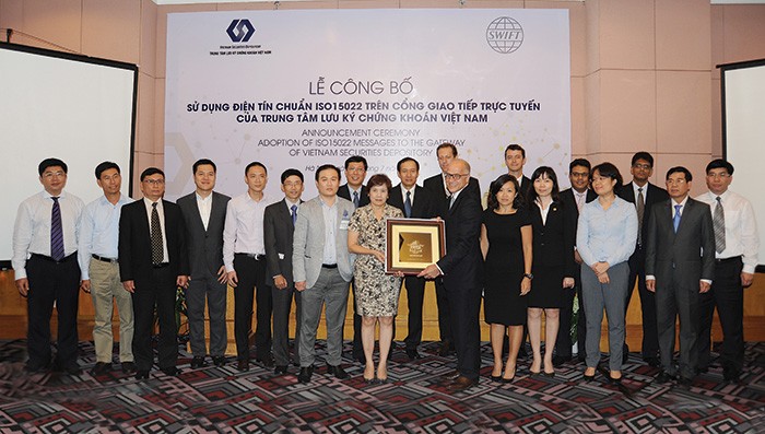 Chủ tịch VSD bà Phương Hoàng Lan Hương trao quà lưu niệm cho ông Alain Raes, Tổng giám đốc khu vực châu Á - Thái Bình Dương và khu vực châu Âu - Trung Đông - 
châu Phi của SWIFT, với sự chứng kiến của lãnh đạo UBCK và các thành viên của VSD 