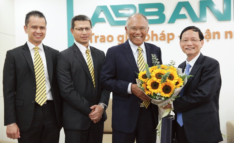 Chủ tịch Vũ Văn Tiền đón (ngoài cùng bên phải) tặng hoa ông Tan Sri Dato’ Megat Zaharuddin Megat Mohd Nor, Chủ tịch HĐQT Maybank
