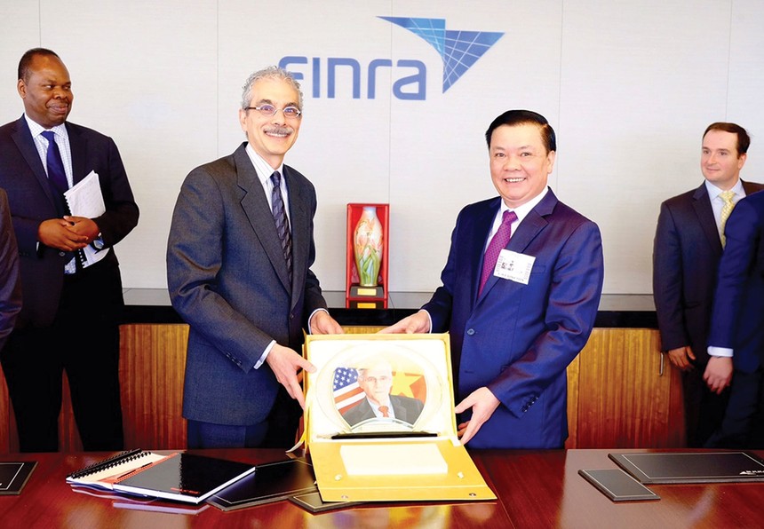 Bộ trưởng Đinh Tiến Dũng tặng quà cho Tổ chức Finra, Tổ chức giữ gìn sự liêm chính trên thị trường 99Kl99 link đăng nhập Mỹ, trong chuyến xúc tiến Kl99ok phiên bản mới tại New York, tháng 7/2015 